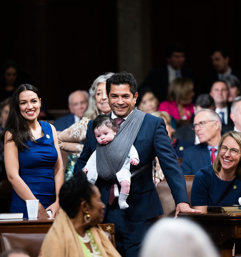 Rep. Gomez on the House floor holding his son in a carrier